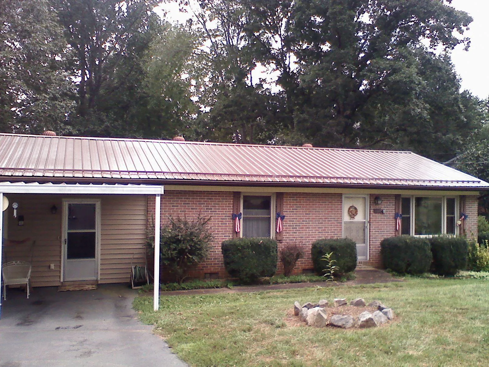 Bronze metal roof and carport on a brick ranch home — Roof Repair work by our crew in Shipman