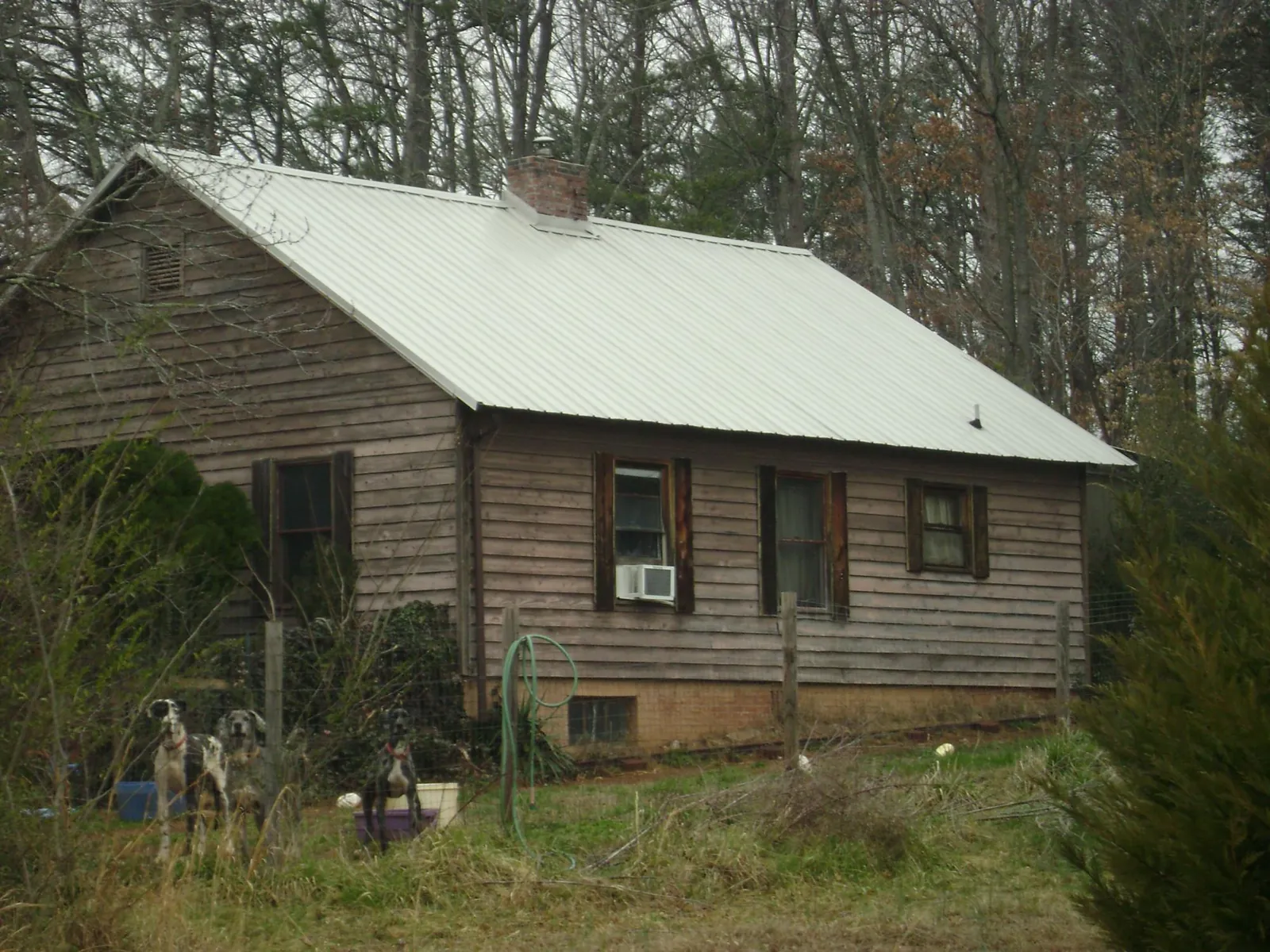 White metal roof on an old wood sided farmhouse, from a Metal Roof Installation job in Shipman